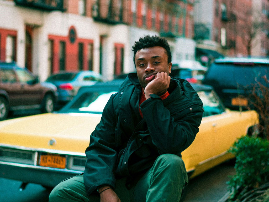 Man sitting in front of yellow car